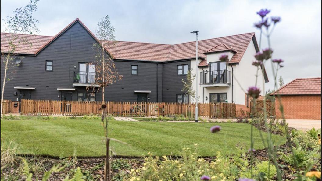 A new large house with a lawn in front of it