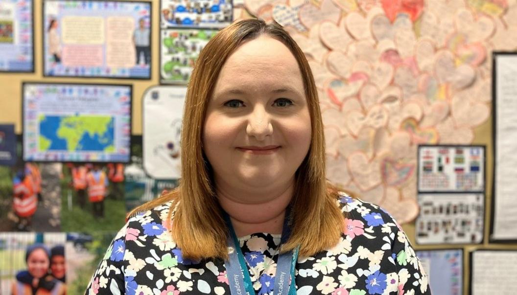 School teacher Rebecca Laird standing in front of a school notice board 