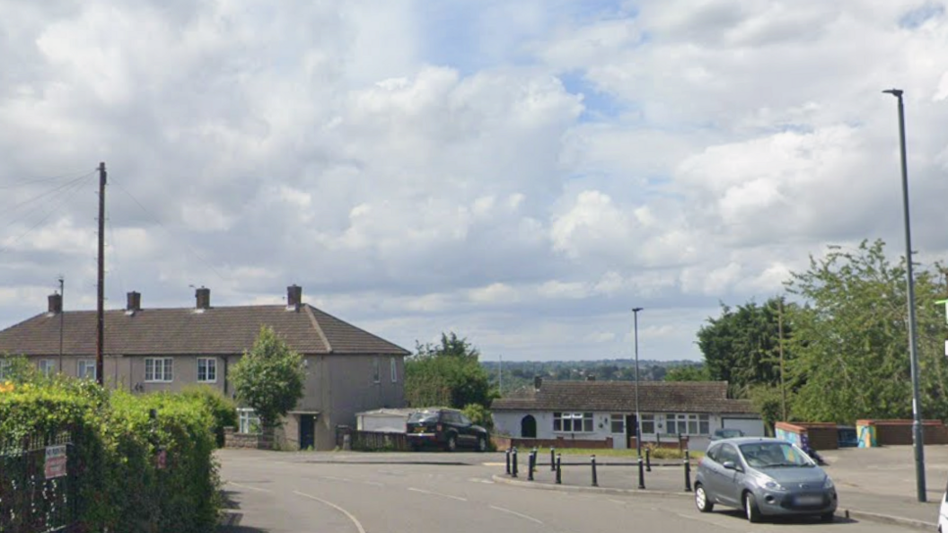 Google image of a Road with houses and a car