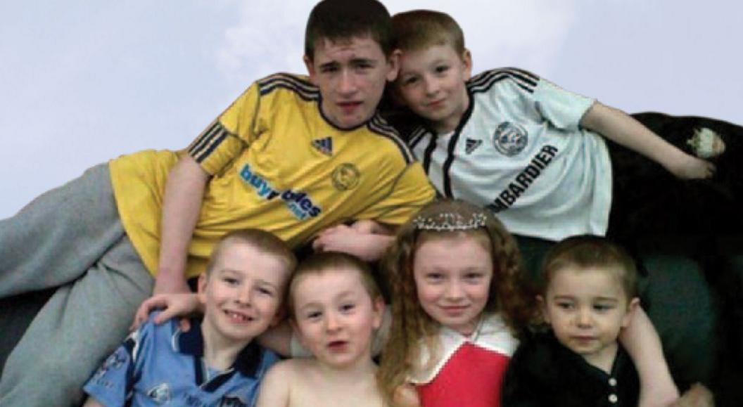 Children grouped together smiling for a family picture