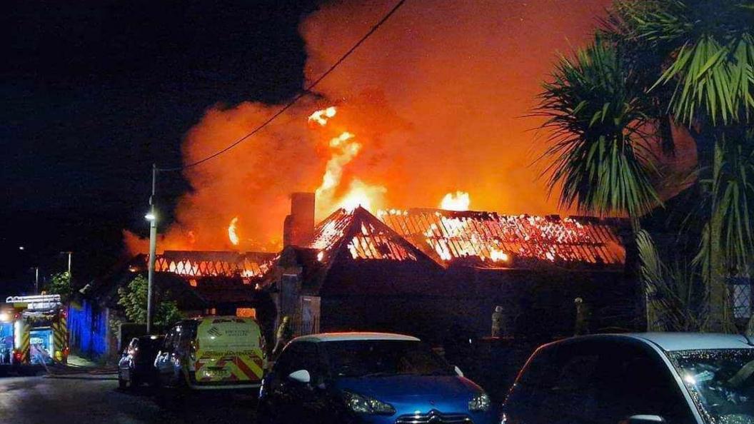 Fire at the derelict school. Flames are ripping through the roof.