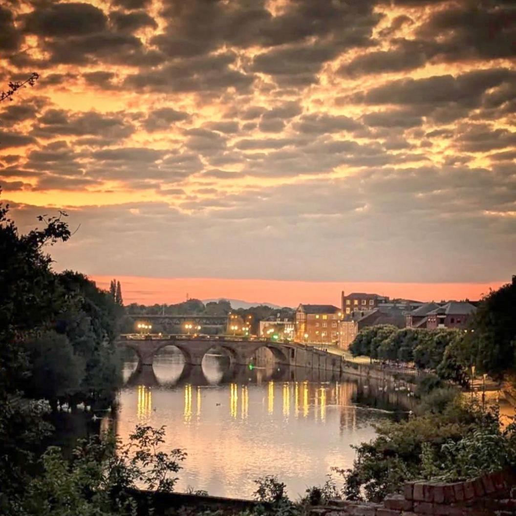 Sunset over the River Severn at Worcester. The city's river bridge is in the centre of the image and the sunset is reflected in the water