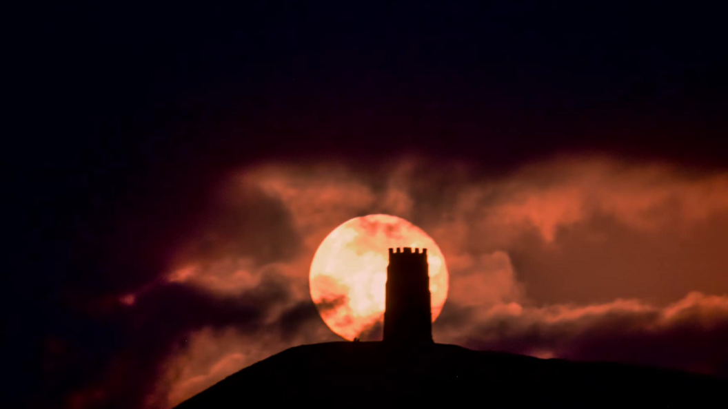 The Glastonbury Tor in front of the reddish super moon