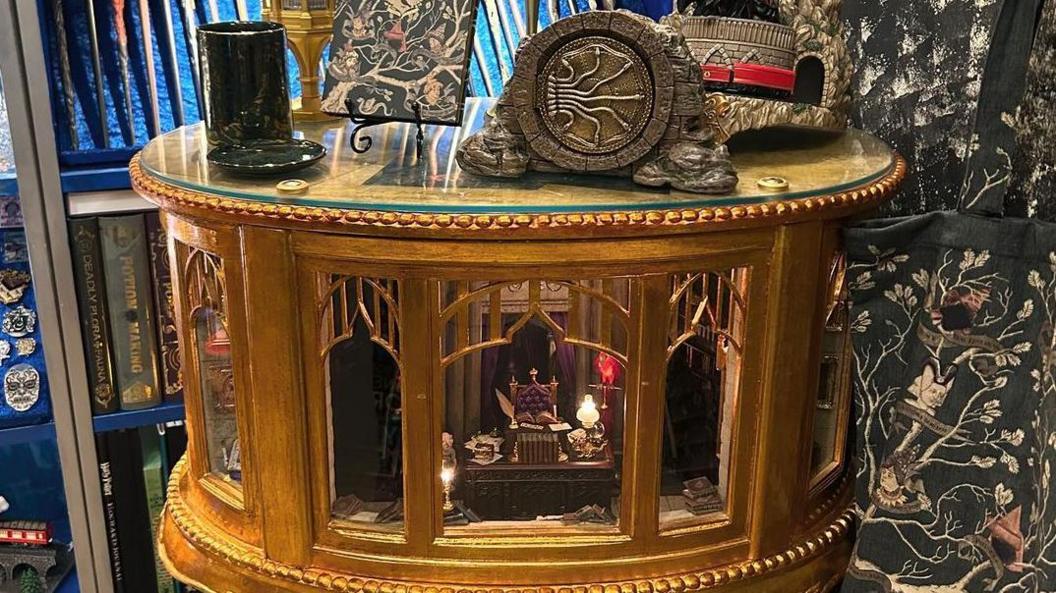 The handmade gold leaf cabinet with a miniature replica of Dumbledore's office