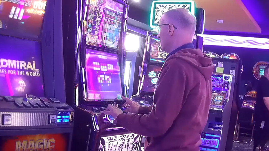 Undercover BBC reporter Greg Clark standing playing video games machines at an Adult Game Centre