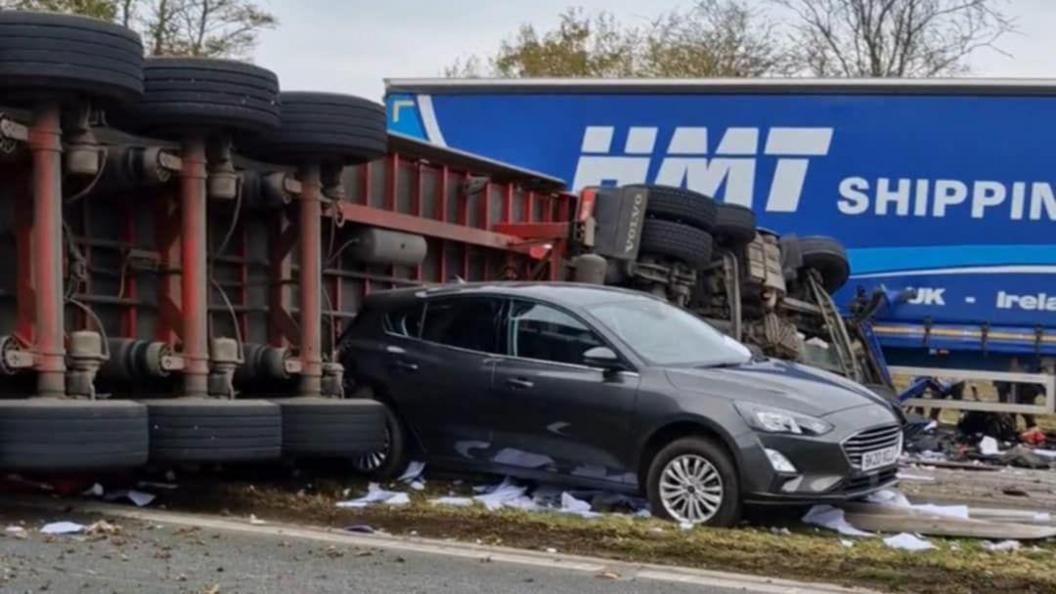 Overturned lorry wedged against car on M6