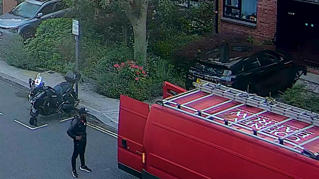Yostin Mosquera stands looking at a red van which a driver used to transport him and the suitcases from London to Bristol. The van is parked outside 9 Scotts Road, where Albert and Paul lived. Mosquera is wearing the black leather jacket, red t-shirt and hat he was later found in by police.