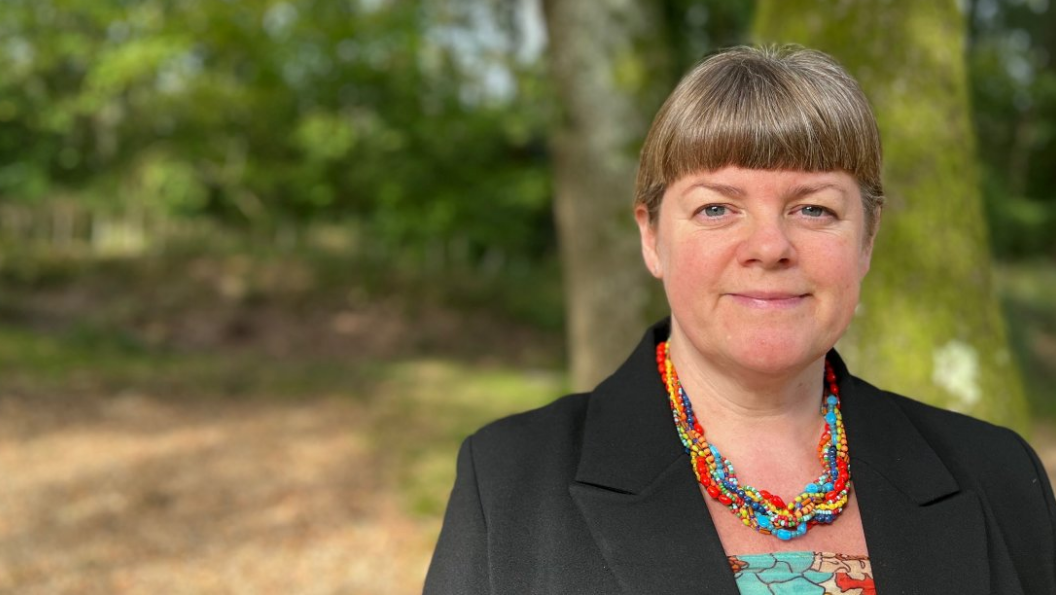 Serena Wootton smiling while standing in woodland