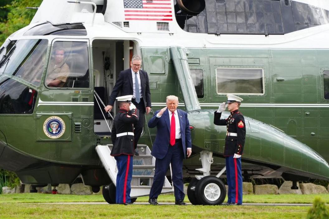 Donald Trump and kiwer starmer step off a helicopter and salute men in uniforms
