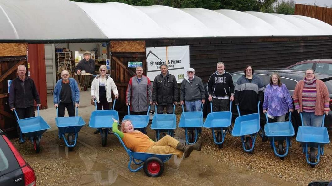 Volunteers with their blue wheelbarrows