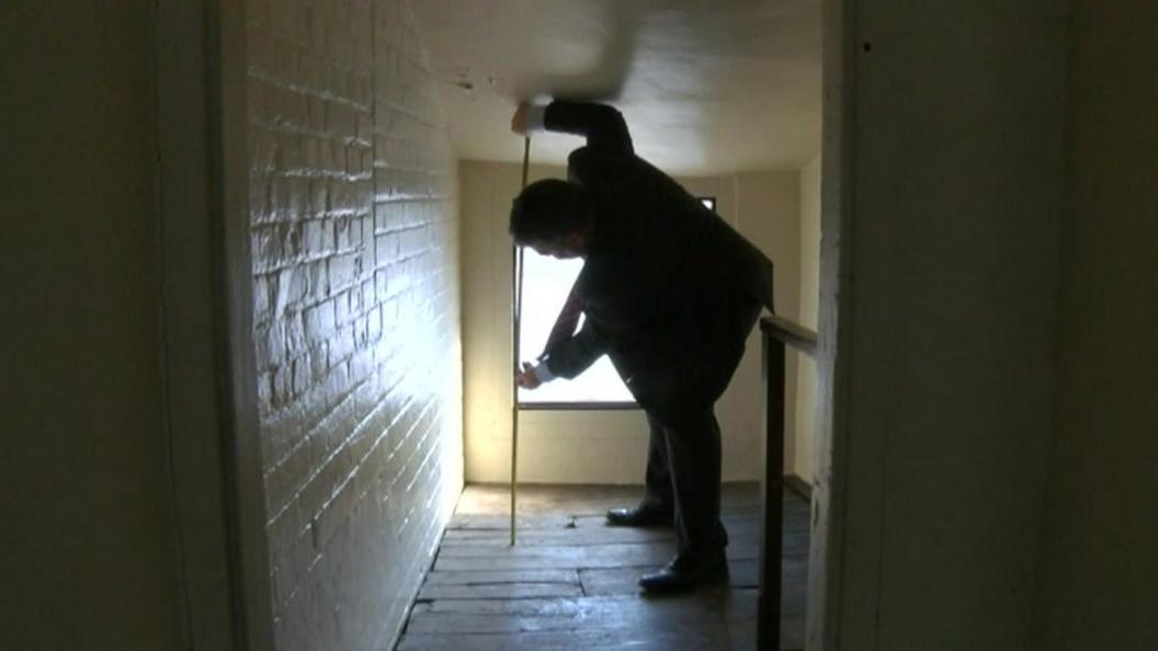 Kevin Burch measuring the inside of a house