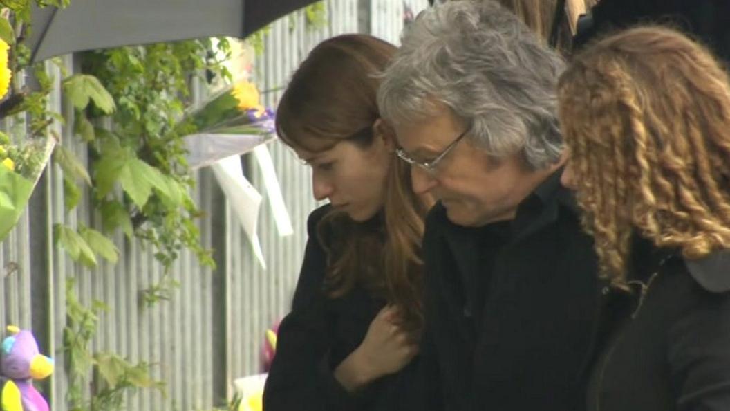 Ann Maguire's family inspect floral tributes