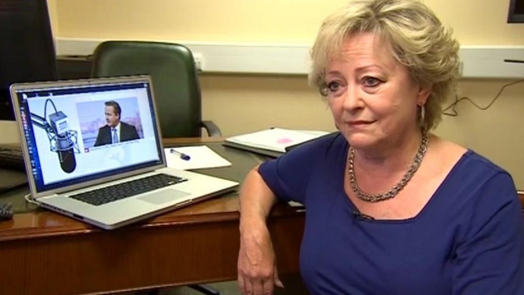 Ann Barnes in front of picture of David Cameron