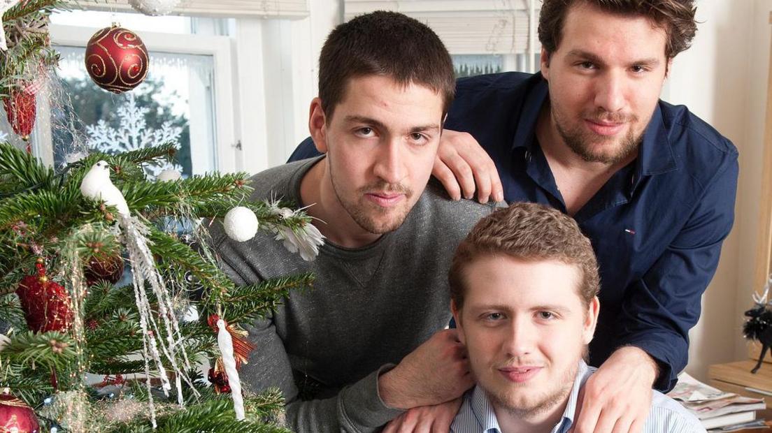 Jordan with his brothers next to a Christmas tree