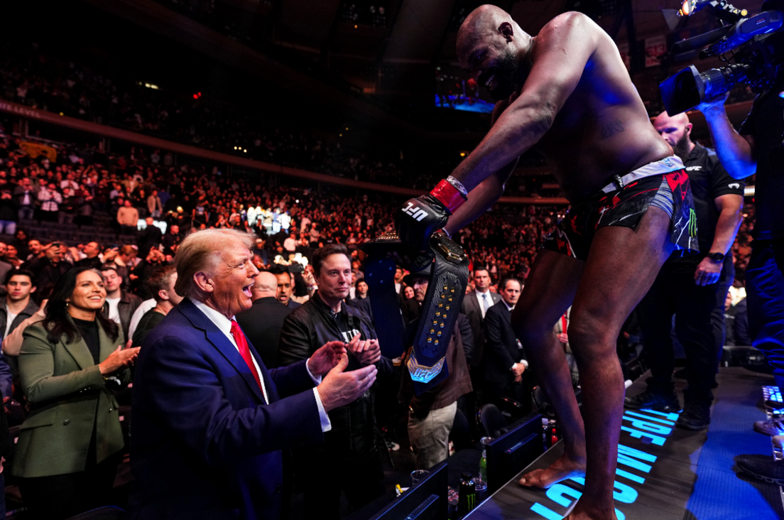 Jon Jones celebrates by handing Trump his title