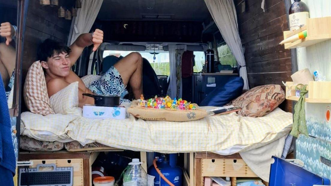 Milo Beimers pictured on a bed in the back of a van