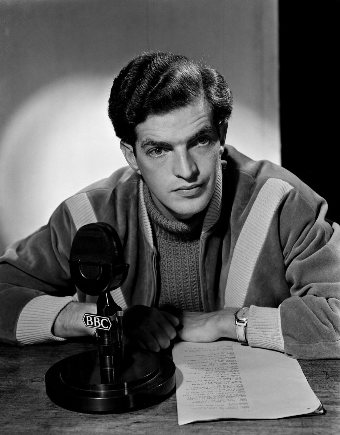 Head and Shoulders image of Gabriel Woolf sitting at a desk with a script and a ˿ microphone