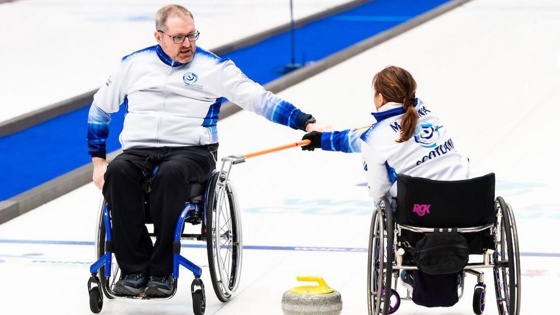 Wheelchair curlers Hugh Nibloe and Charlotte McKenna in action