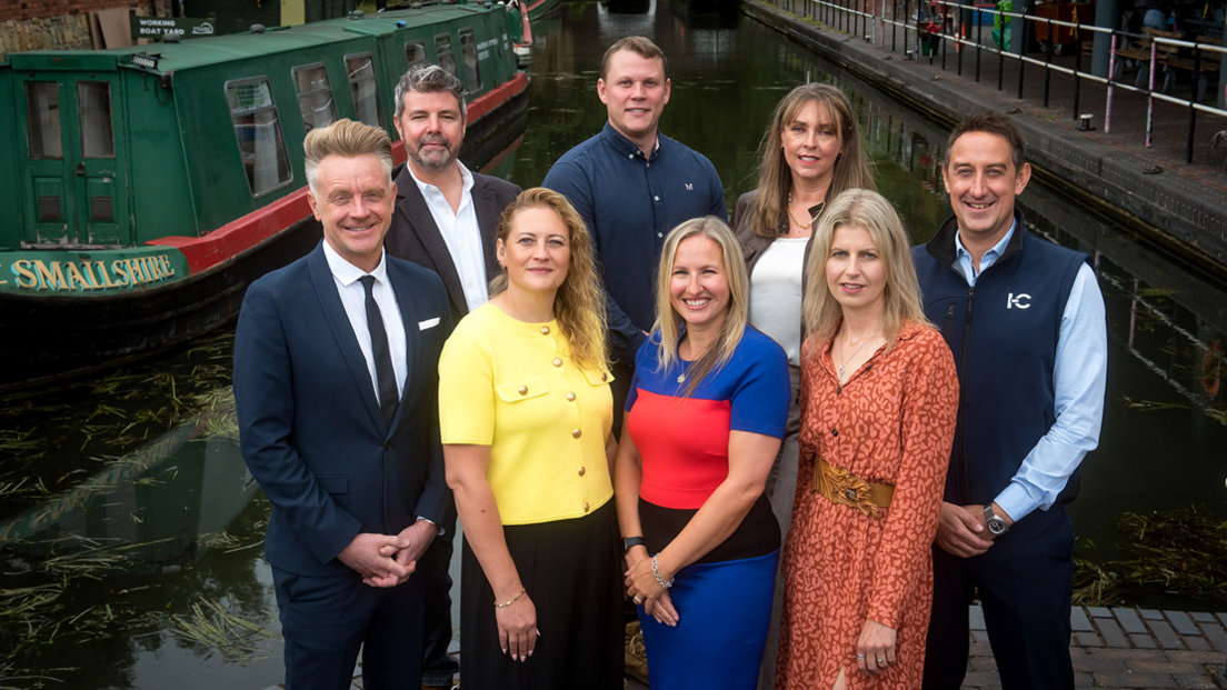 A group of four women and four men stand at Dudley Canal & Caverns in front of a green and red canal boat which has the word "smallShire" on it. From left - Paul Hull of KMB Shipping Group; Antony Burns of Paycare; Carolyn Smith of TPSquared; Paul Crofts of Dudley Canal & Caverns; Sarah Moorhouse of Black Country Chamber of Commerce; Jane Sommerville, Bowers & Jones; Lisa Cowley of Beacon Centre for the Blind, and Gareth Jones from In-Comm Training. 