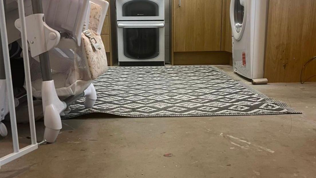 Concrete floor with rug on in kitchen