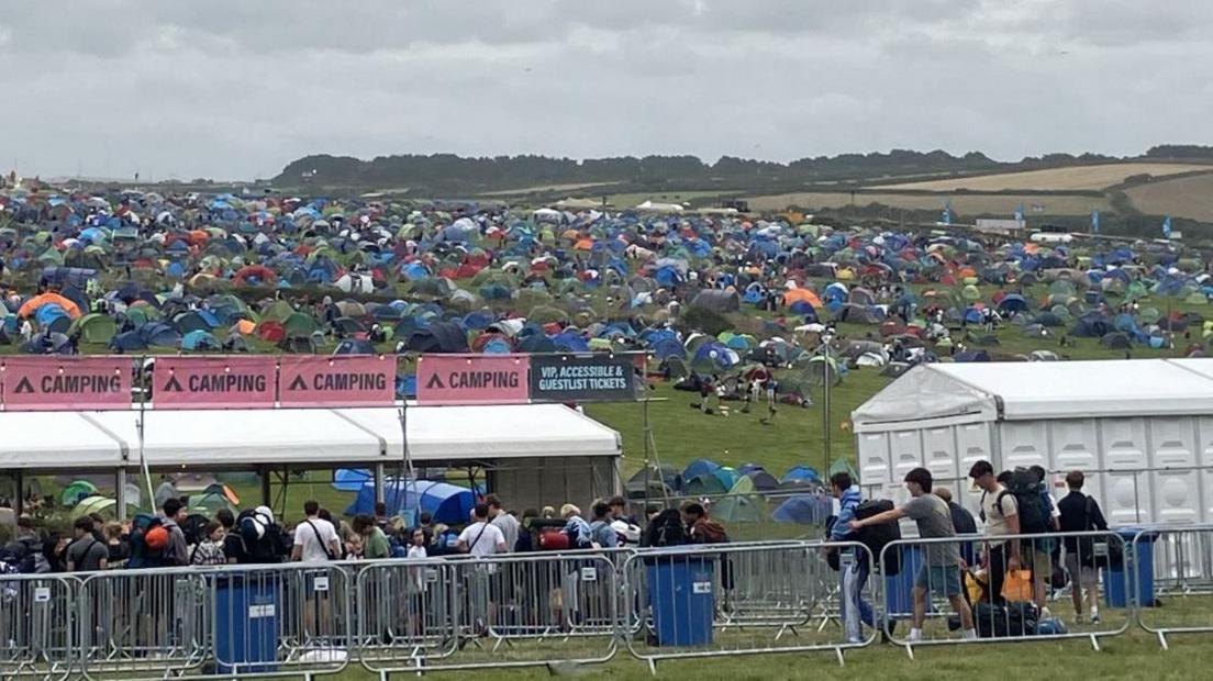 A queue to get into the camping section of Boardmasters, and tents on a hill 