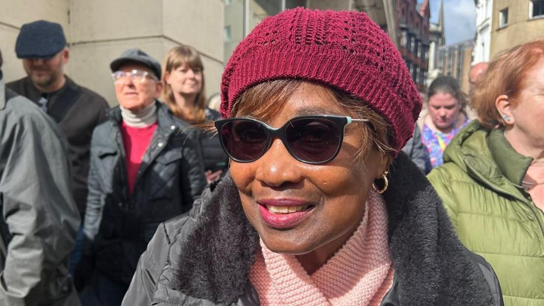 A close up of a woman wearing sunglasses in a crowd