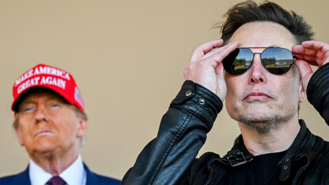 Donald Trump wears a MAGA hat behind Elon Musk, donning sunglasses and wearing a black leather jacket