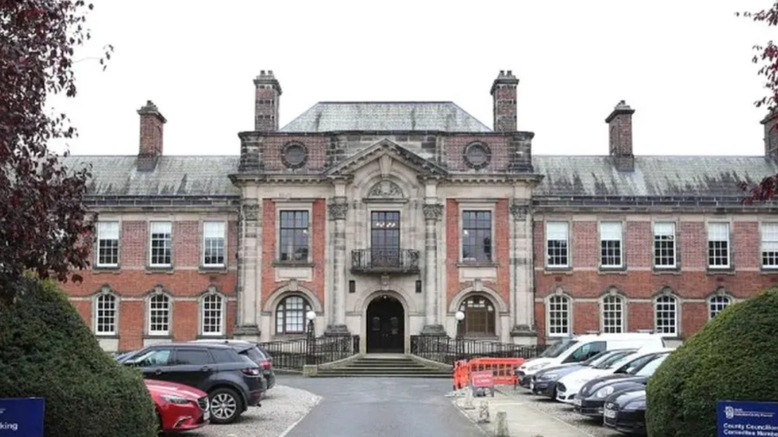 A photo of North Yorkshire Council headquarters. A grand, two-storey building with a number of cars parked outside. 