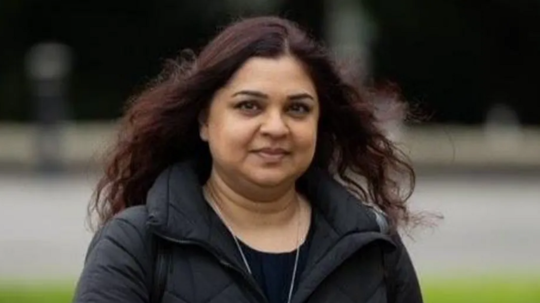 Tanya Nasir looking at the camera, she is wearing a black coat and t-shirt and her brown hair is down