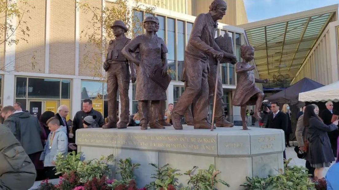 The covid memorial in central Barnsley, large figures of adults and a child in bronze on top of a stone plinth