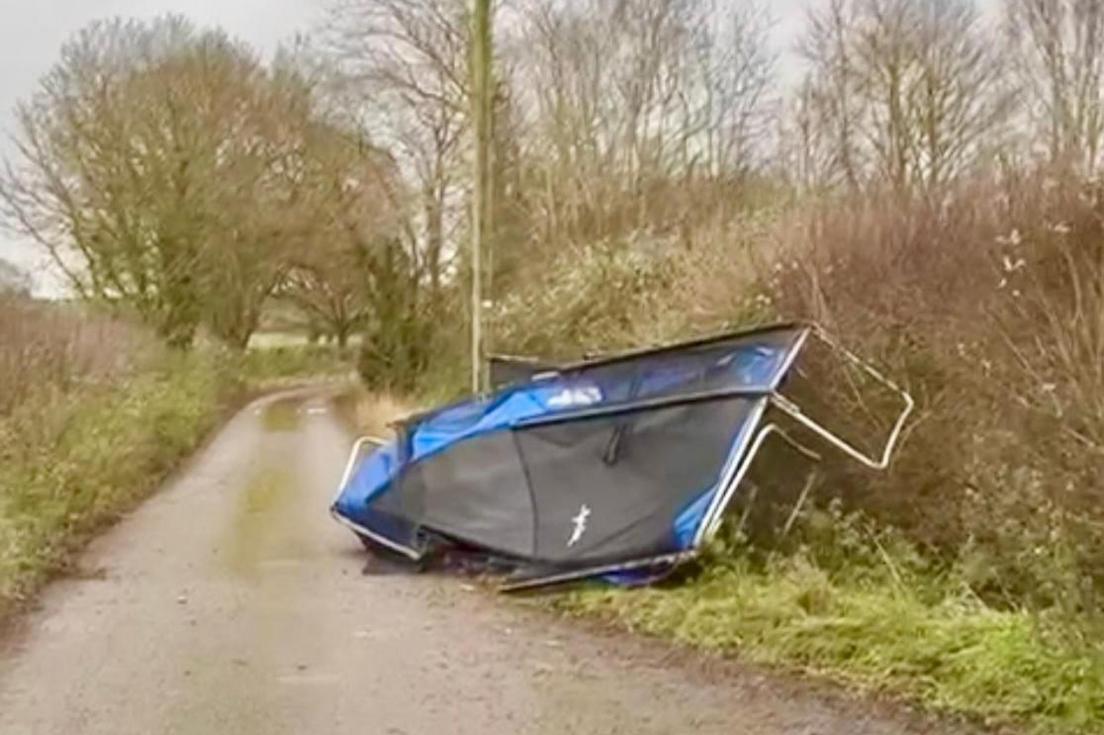 A mangled, blue trampoline is left on the side of a road in Leamington Spa after the storm.