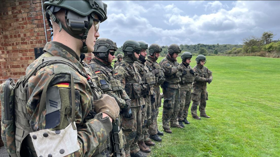 A line of soldiers wearing camouflage uniform and helmets