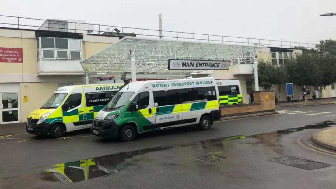 Exterior shot of main entrance of Frimley Park hospital with ambulances outside 