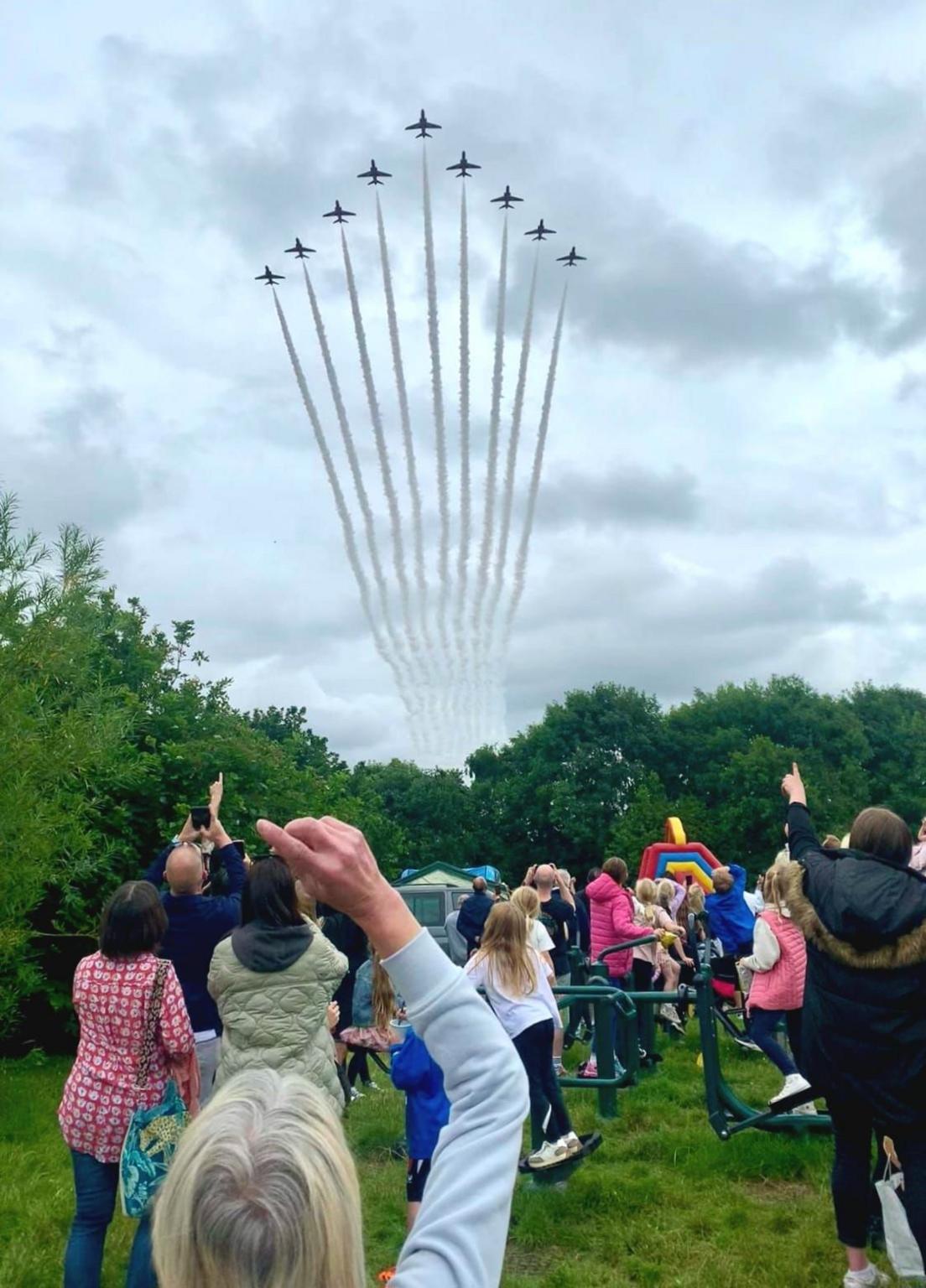 People watching the Red Arrows flying overhead