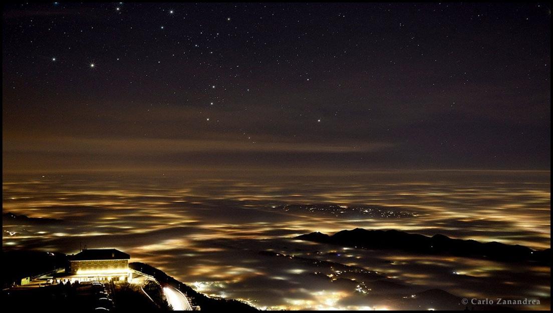 Orion rising over lights and fog in the province of Treviso in north east Italy