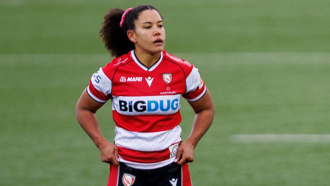 Tatyana Heard standing on the pitch during a match for Gloucester-Hartpury holding her shorts