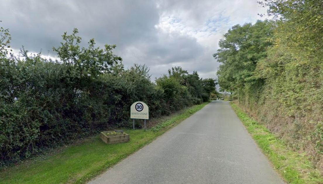 The road into Whitestone near Exeter, showing the Whitestone sign