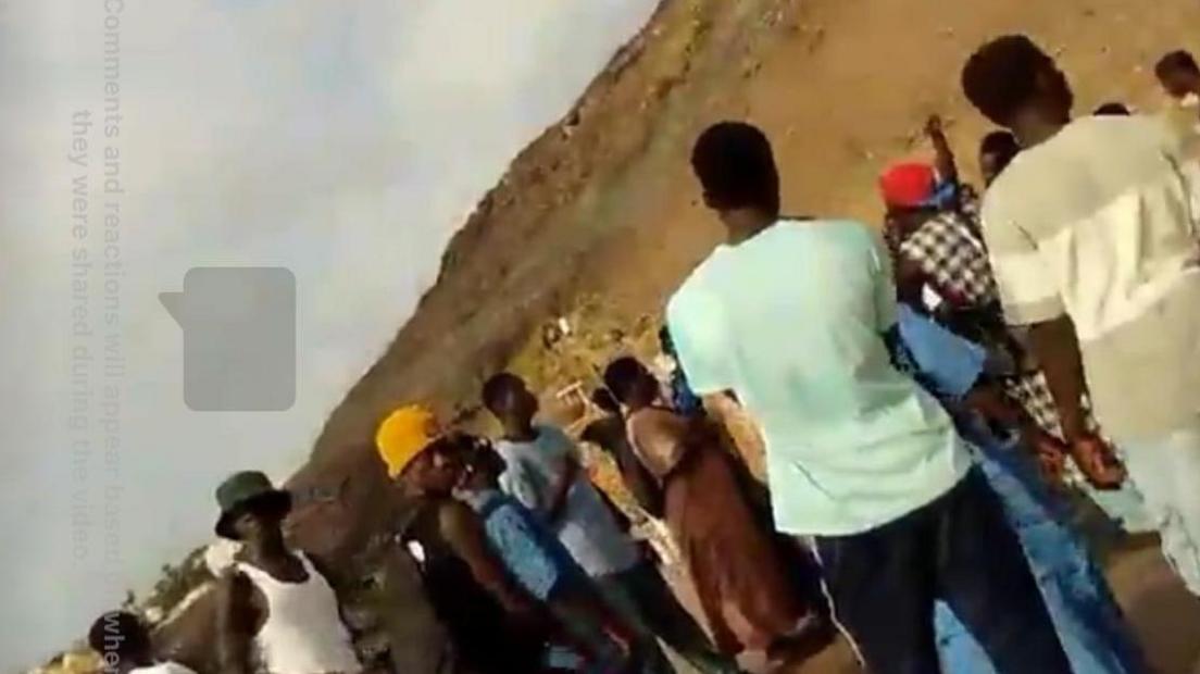 A still taken from James Nunan's Facebook Live broadcast. It shows people, believed to be migrants, gathered on a beach.