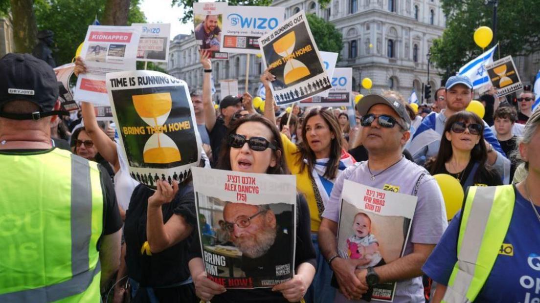 Attendees hold up images of hostages and placards for the Women's International Zionist Organisation (WIZO)