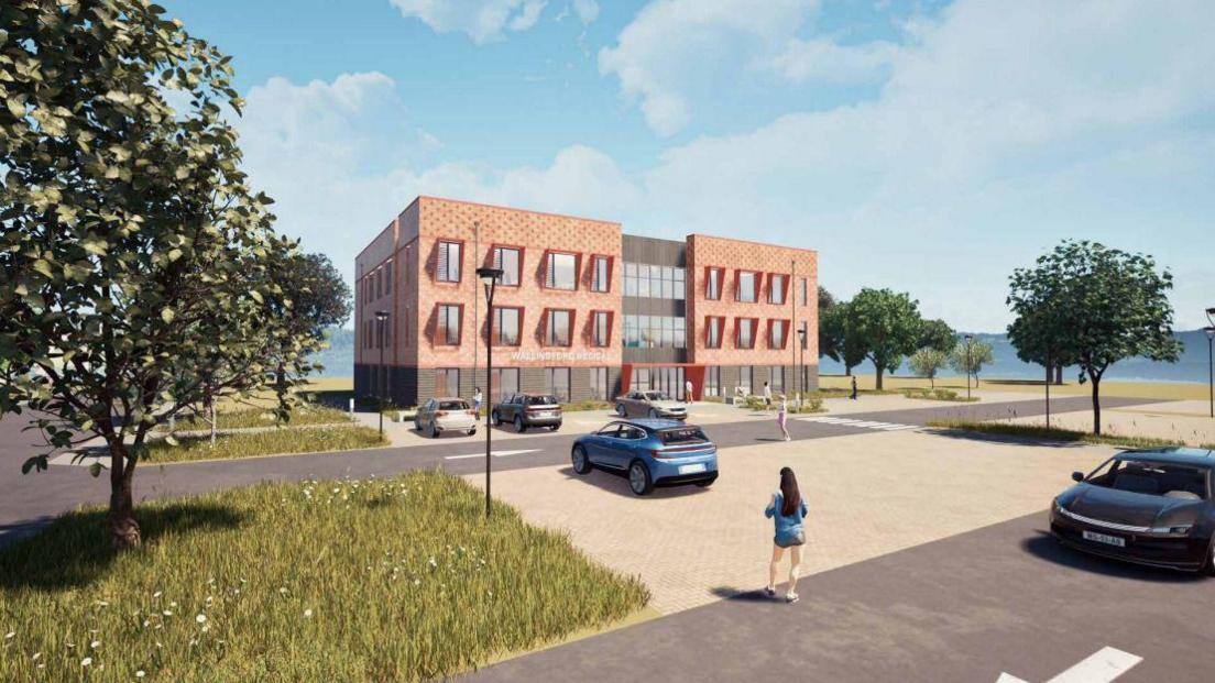 A CGI image of the proposed GP surgery in Wallingford. The image shows a peach coloured three-storey rectangular building with large square glass windows. There are cars parked in bays in front of the building and larger sections for cars to park over the road. There are trees dotted around the image, the sky is a bright blue with clouds and there is a CGI image of a woman with long brown hair walking towards the building.
