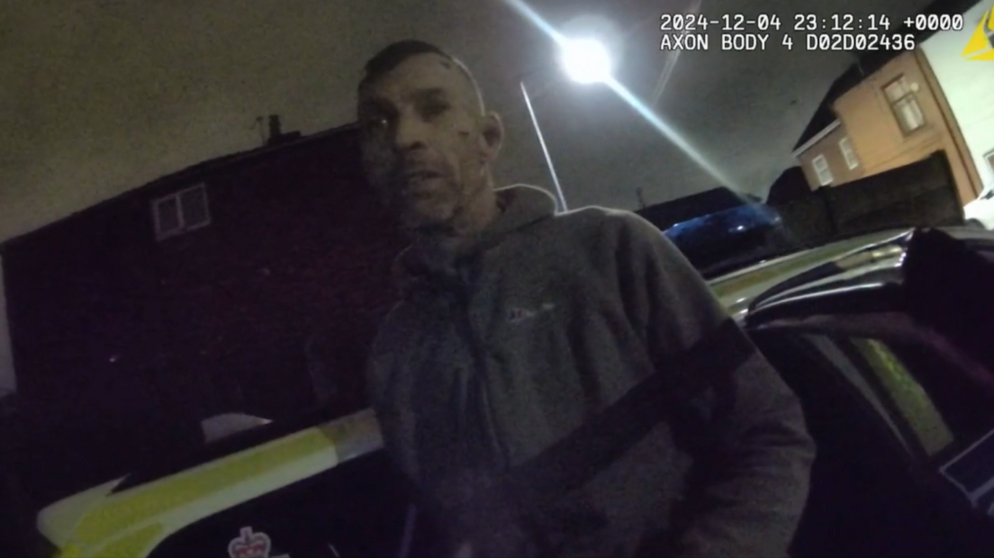 Police bodycam footage of Draper, with two blood marks on his face and wearing a hoodie, being arrested outside his home in the dark