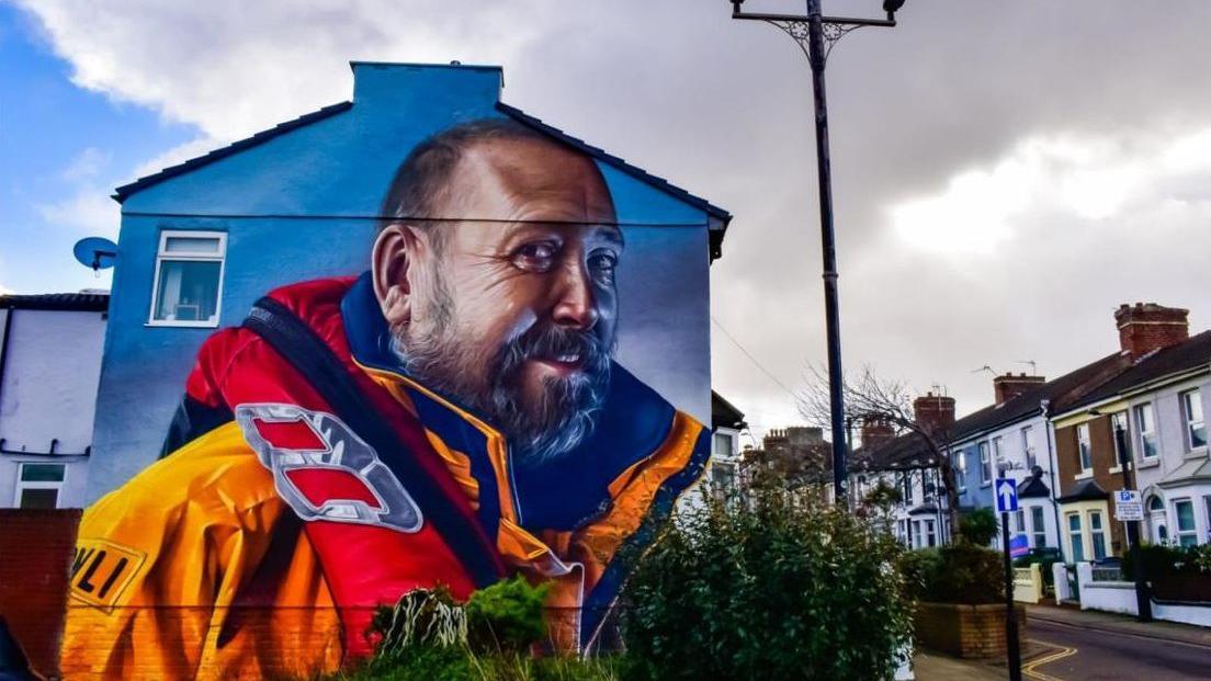 A mural of a lifeboat volunteer on the side of a house in New Brighton