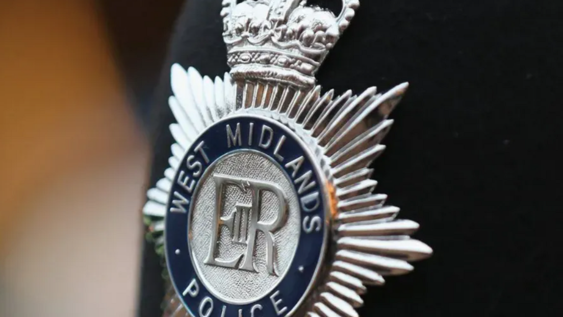 A silver badge saying West Midlands Police