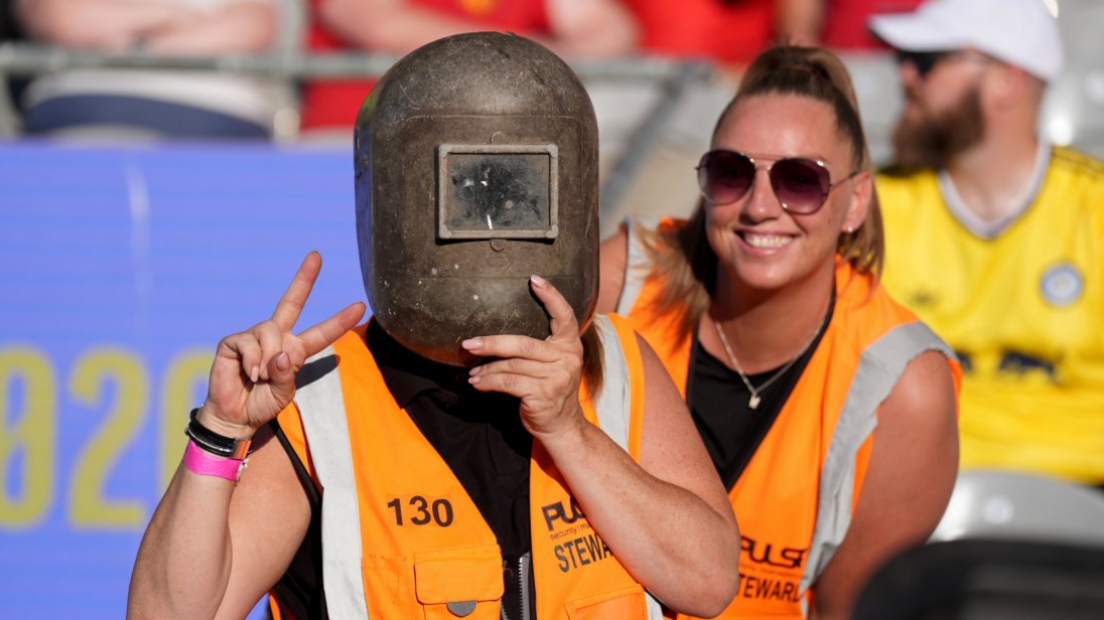 Stewards wearing welding helmets to watch the solar eclipse ahead of a pre season match at Croke Park, Dublin