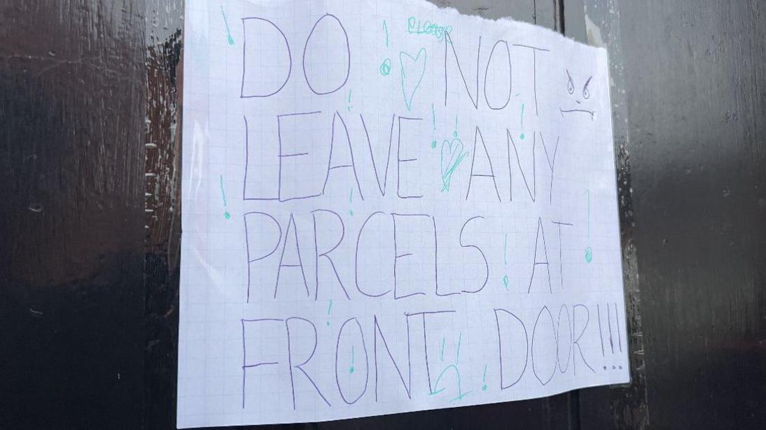 A sign on the glass of a front door that says in capital letters: "Do not leave any parcels at front door!!!"