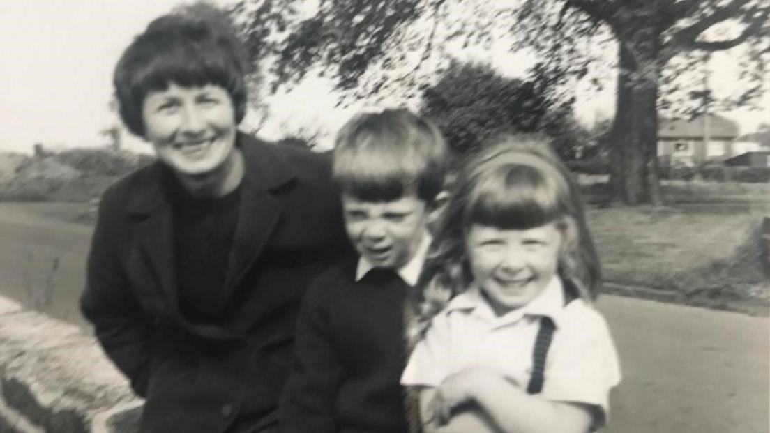 A black and white picture of Dorothy Graham with two young children 