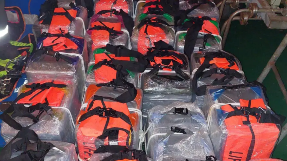 Bags, some black and some hi-vis, wrapped in plastic and lined up on the ground