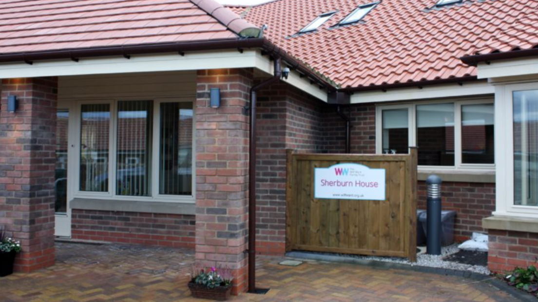 The front of a building with a sign reading “Sherburn House” outside.
