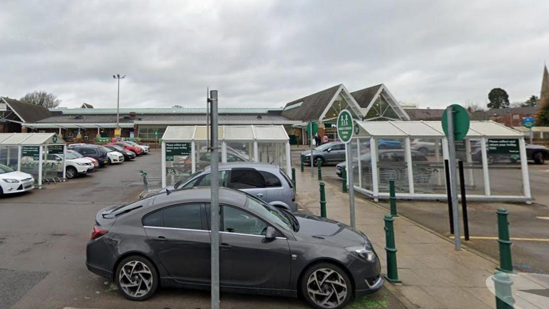 Supermarket car park showing vehicles and trolley parks