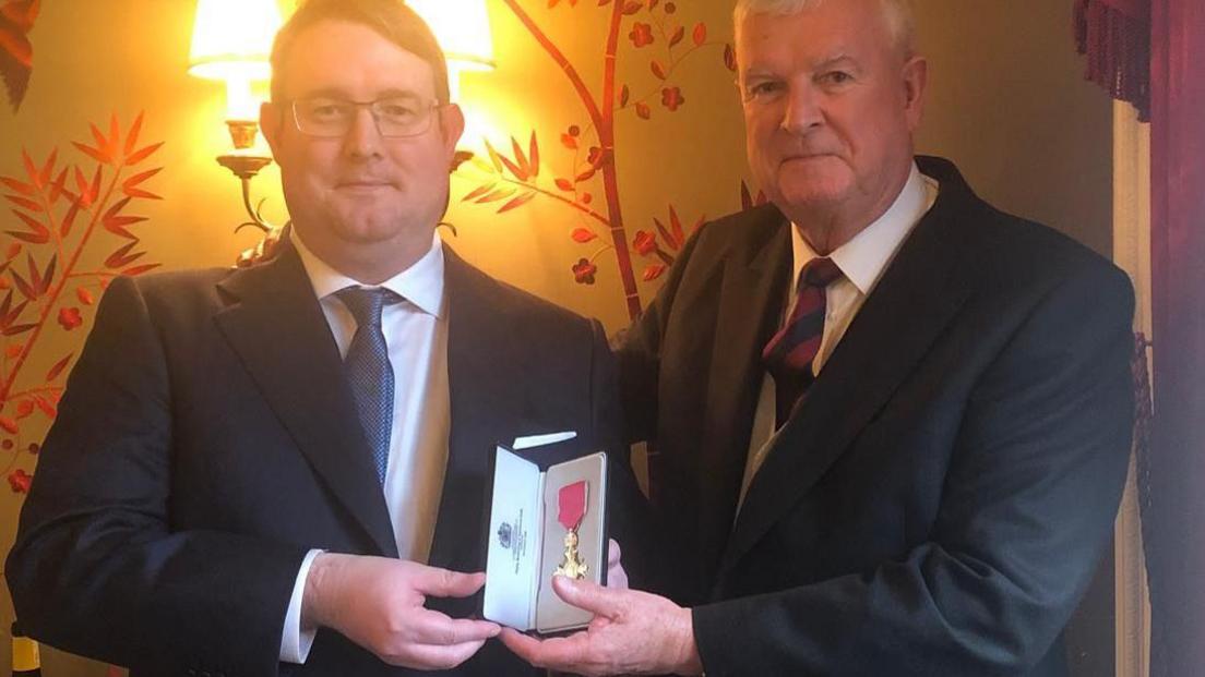 Hywel and Alan Peterson pictured with Alan's OBE